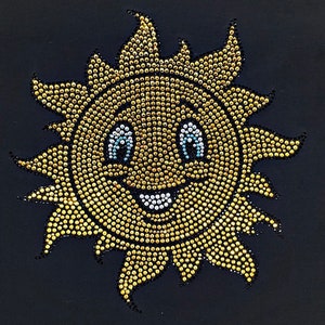 May include: A yellow sun with a smiling face made of rhinestones. The sun has blue eyes and a white smile.