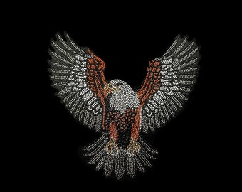 May include: A white and orange bald eagle with its wings spread wide, made of rhinestones. The eagle is facing forward with its head turned to the side.