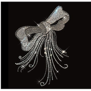 May include: A silver rhinestone bow with a long, flowing tail of rhinestones. The bow is on a black background.