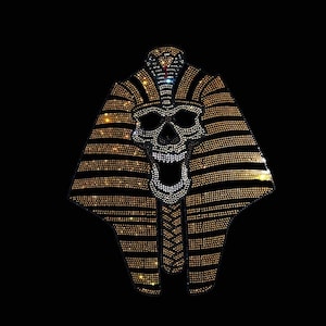 May include: A gold and silver skull with a cobra on top, in the style of an Egyptian pharaoh's headdress, made of rhinestones.