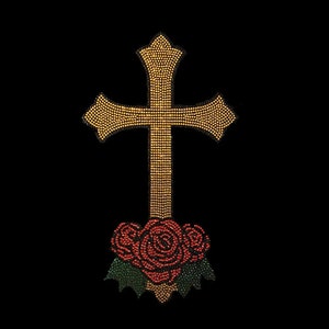 May include: A gold cross with a red and green rose at the bottom. The cross and rose are made of rhinestones.