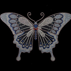 May include: A black background with a large, silver, blue, and red rhinestone butterfly design.