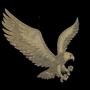 May include: A gold eagle silhouette made of rhinestones on a black background.