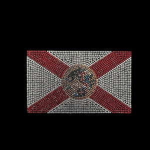 May include: A mosaic-style representation of the Florida state flag, featuring red and white rhinestones forming the flag's design. The flag's emblem is in the centre, set against a black background. The design is made of small, sparkling stones.