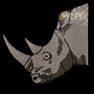 May include: A close-up of a rhinoceros made of rhinestones. The rhinestones are arranged in a pattern that creates the shape of the rhinoceros's head, horn, and body. The rhinestones are silver and black.