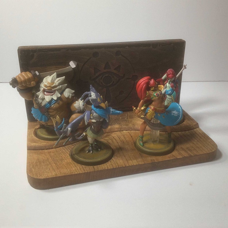 Display your Four Champion Amiibos with pride! This exclusive stand features 4 spots for your Amiibos, and a beautiful Sheikah Slate design.