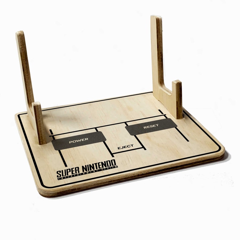 May include: A wooden Super Nintendo Entertainment System console stand. The stand has a light wood finish with black text and graphics, including the words "POWER", "EJECT", and "RESET". The Super Nintendo logo is also visible.