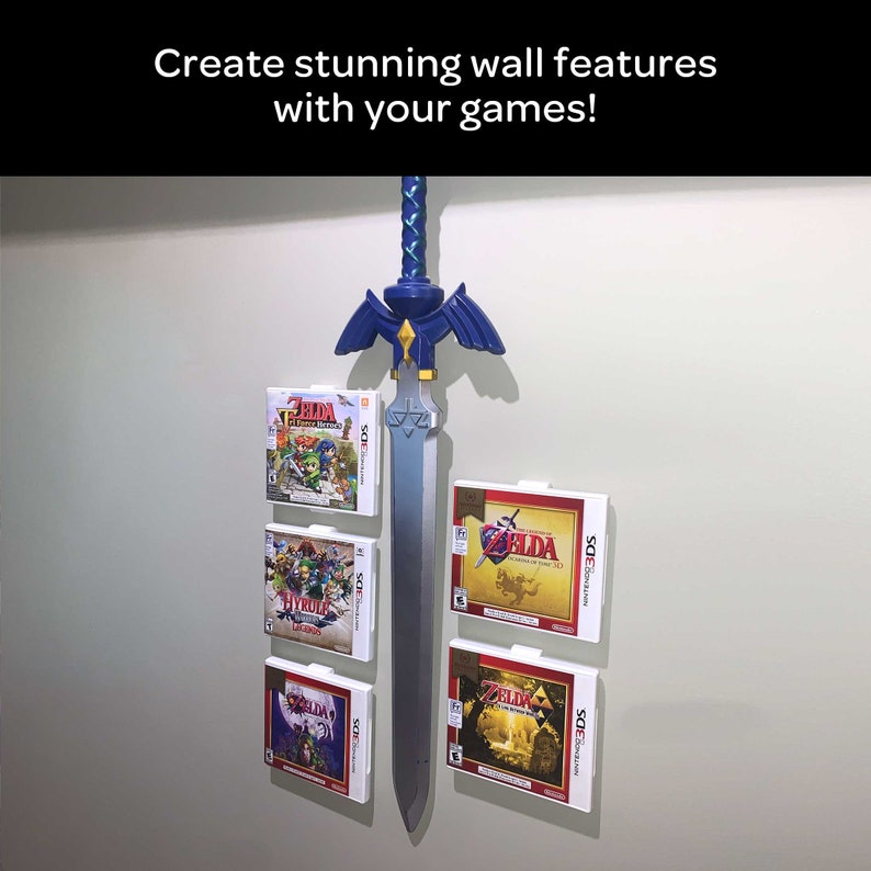 May include: A silver sword with a blue and green handle is mounted on a wall with four video game cartridges displayed on either side of the sword. The cartridges are for the Nintendo 3DS and feature the Legend of Zelda logo and artwork.