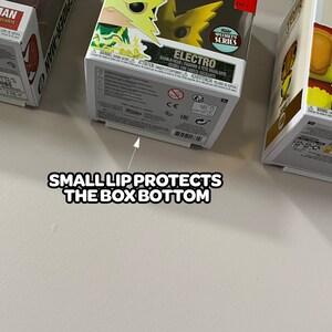 May include: A yellow and green Funko Pop! figure of Electro from the Marvel Comics universe. The figure is in a clear plastic box with a white base. The box has a white lip that protects the bottom of the box. The box also has a black and white label with the text "Funko Specialty Series" and "Electro".