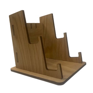 May include: Wooden stand with multiple slots for displaying items. The stand is made of light brown wood and has a simple, modern design.