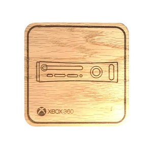 Op de afbeelding: Een houten onderzetter met een lasergegraveerd ontwerp van een Xbox 360-console. De onderzetter is bruin en heeft een vierkante vorm. De tekst "XBOX 360" is ook gegraveerd op de onderzetter.