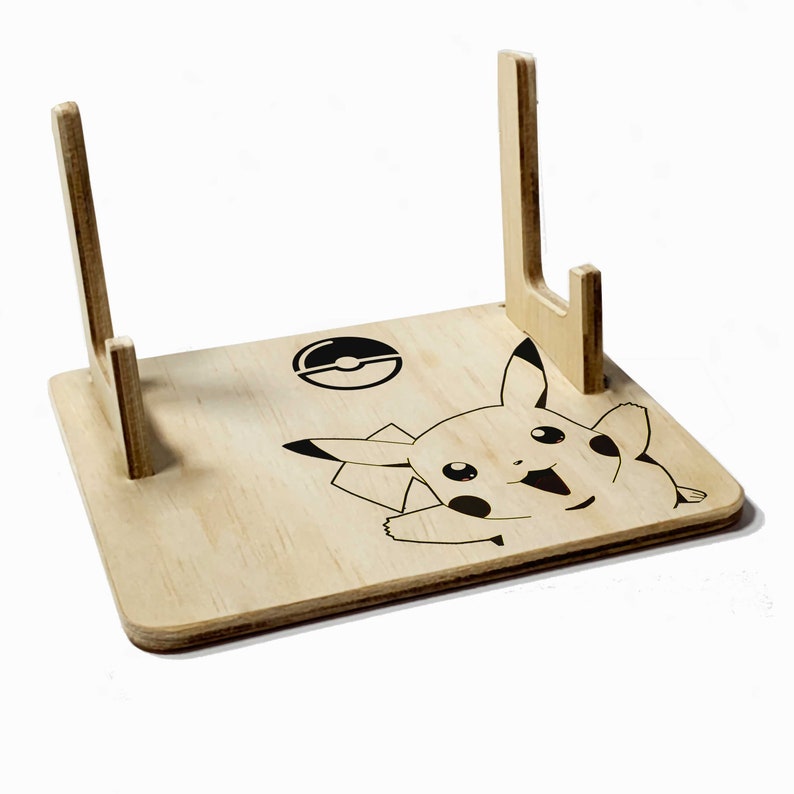 May include: A wooden stand with two upright supports, featuring a black and white graphic of Pikachu and a Pokeball.