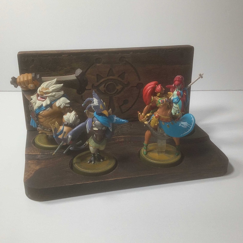 Display your Four Champion Amiibos with pride! This exclusive stand features 4 spots for your Amiibos, and a beautiful Sheikah Slate design.