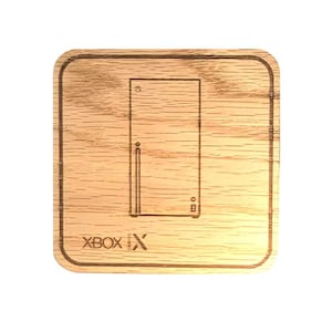 Op de afbeelding: Een houten onderzetter met een lasergegraveerd ontwerp van de Xbox Series X-console en de tekst "Xbox Series X".