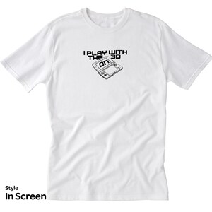 May include: White t-shirt with a black and white graphic of a Nintendo 3DS handheld gaming console. The graphic includes the text "I Play With The 3D".