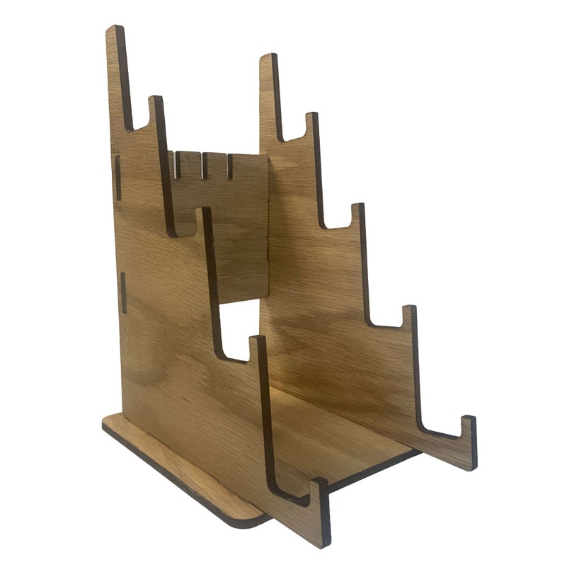May include: Wooden stand with five slots for holding items, such as records or books. The stand is made of light brown wood and has a simple, modern design.