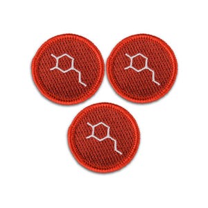 May include: Three circular embroidered patches in a vibrant red color. Each patch features a white stitched chemical structure design in the center. The patches have a textured fabric appearance with a clean, finished border around the edges.