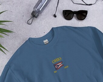 May include: A blue sweatshirt with a gold embroidered design featuring the word "OHIO" and a flag with the text "Est. 1803".