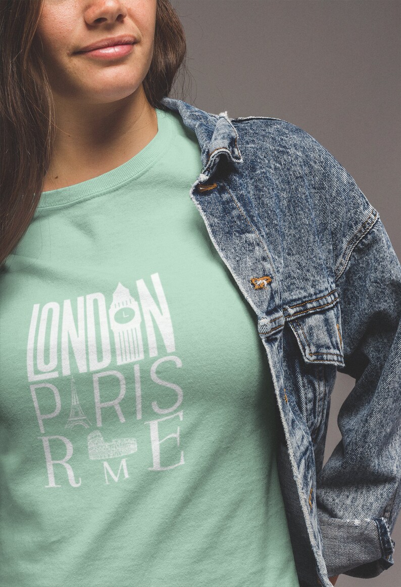 May include: A light green t-shirt with a white graphic design that says "LONDON PARIS ROME" with iconic landmarks from each city.