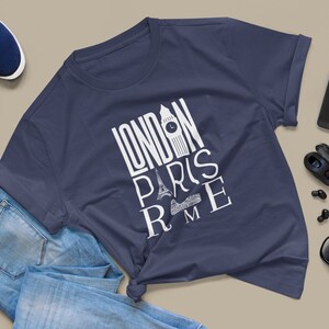May include: A navy blue t-shirt with a white graphic design that says "LONDON PARIS ROME" with iconic landmarks from each city.