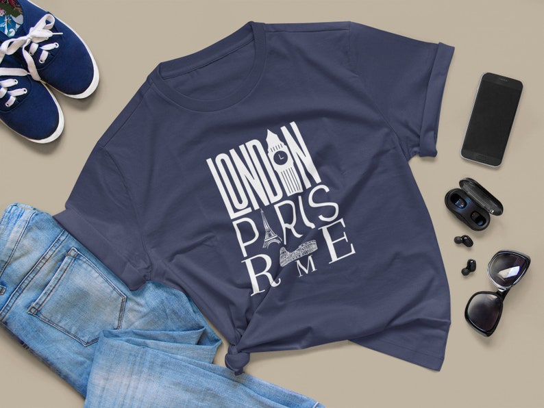 May include: A navy blue t-shirt with a white graphic design that says "LONDON PARIS ROME" with iconic landmarks from each city.