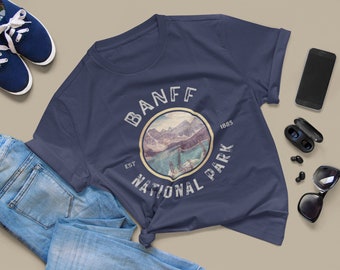 May include: A navy blue t-shirt with a vintage-style graphic of Banff National Park, featuring a mountain scene and the text "Banff National Park Est 1885".