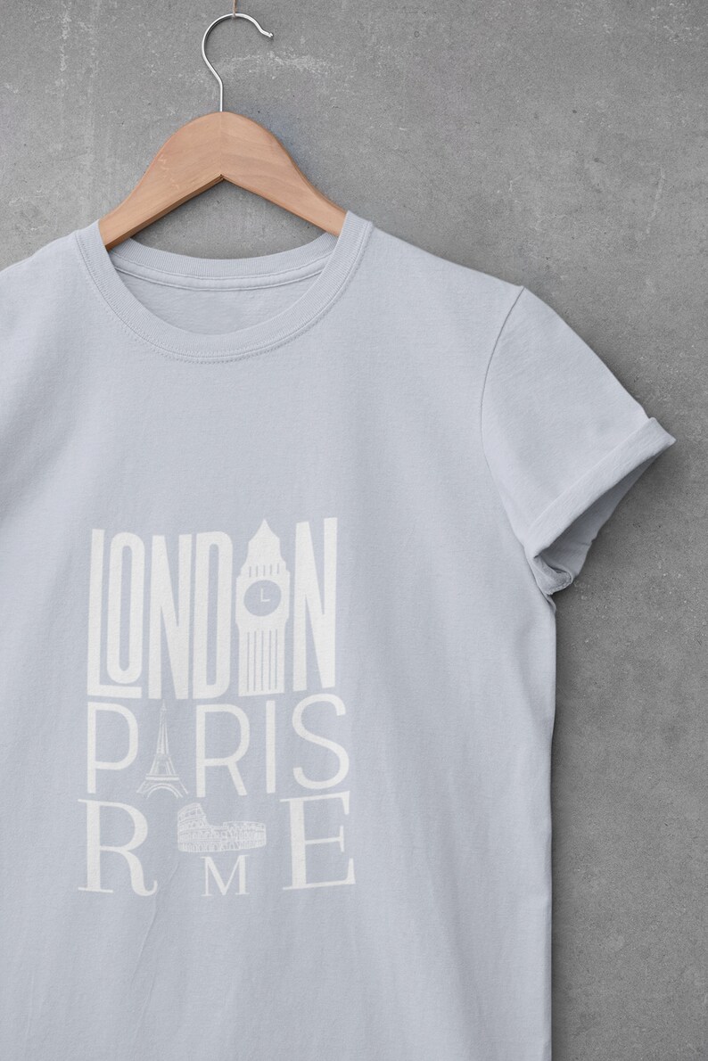 May include: A light blue t-shirt with a white graphic print of the words "LONDON PARIS ROME" with iconic landmarks from each city.