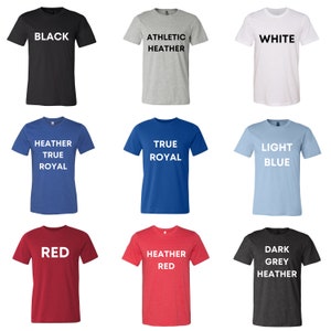 May include: A selection of t-shirts in various colors, including black, white, heather grey, true royal, light blue, red, heather red, and dark grey heather. Each shirt features a different color and text.