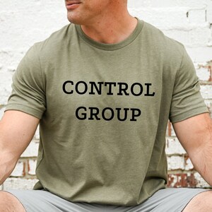 May include: A green t-shirt with the text "CONTROL GROUP" printed in black.