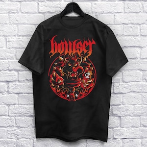Może przedstawiać: Czarny T-shirt z czerwoną i pomarańczową grafiką Bowsera z serii gier wideo Super Mario Bros. Grafika przedstawia Bowsera w ognistym kole z napisem "Bowser" w metalowym foncie nad nim.