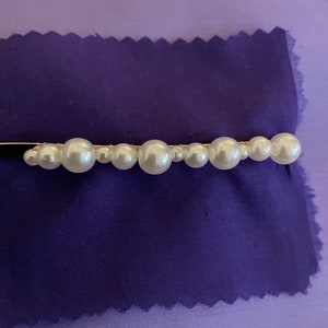 Three sizes of Pearl beads side by side on a slide