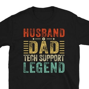 Könnte beinhalten: Schwarzes T-Shirt mit dem Text "HUSBAND DAD TECH SUPPORT LEGEND" in einem Retro-Design mit Used-Look. Der Text ist in Rot-, Gelb- und Türkistönen gehalten. Das Shirt hat kurze Ärmel und einen Rundhalsausschnitt.