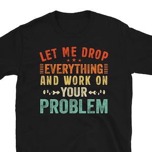 Może przedstawiać: Czarny T-shirt z grafiką w stylu vintage, na której widnieje napis "Let me drop everything and work on your problem".