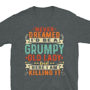 Könnte beinhalten: Ein dunkel-melierter grauer T-Shirt mit einer Grafik im Vintage-Stil, auf dem steht "Never dreamed I'd be a grumpy old lady, but here I am killing it".