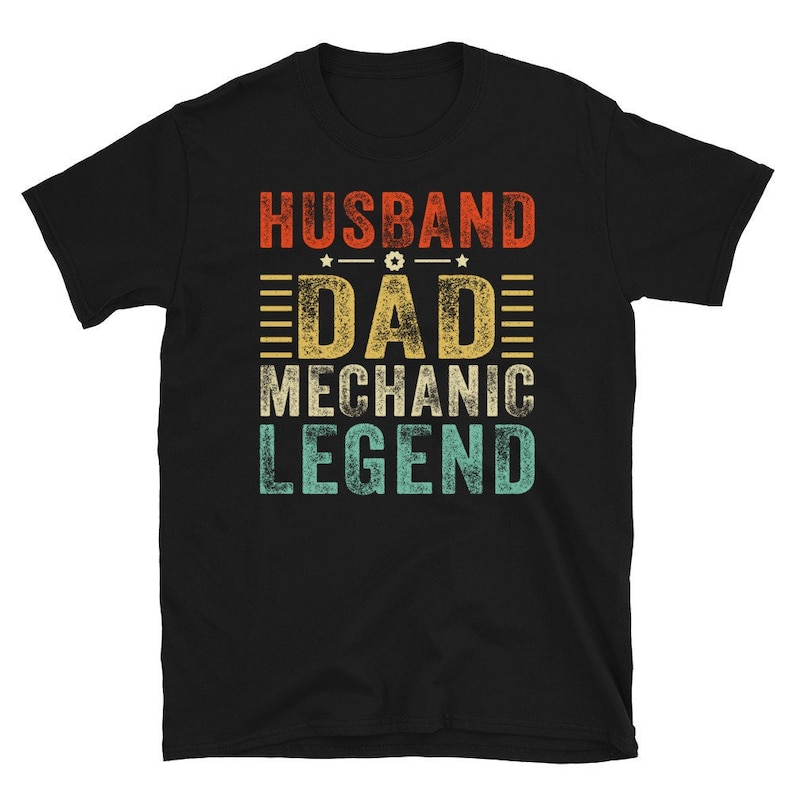 May include: Black t-shirt with a vintage-style graphic that reads "Husband Dad Mechanic Legend".
