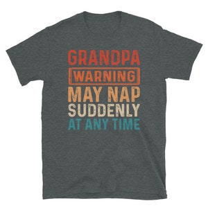 May include: A dark heather grey t-shirt with a vintage-style graphic that reads "Grandpa Warning May Nap Suddenly At Any Time".
