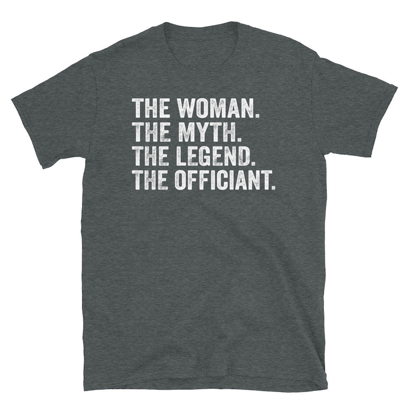 Puede incluir: Camiseta gris oscuro con texto blanco. El texto dice: "THE WOMAN. THE MYTH. THE LEGEND. THE OFFICIANT." La camiseta est&aacute; hecha de un material suave y tiene mangas cortas.