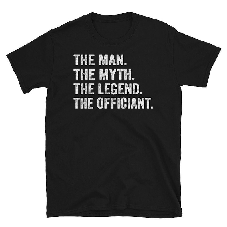 May include: Black t-shirt with white text that reads "The Man. The Myth. The Legend. The Officiant."
