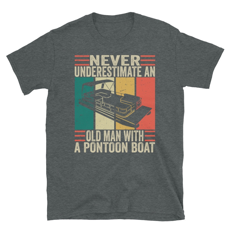 May include: A dark gray t-shirt with a vintage-style graphic that says "Never underestimate an old man with a pontoon boat". The graphic features a pontoon boat with a red, white, and blue color scheme.