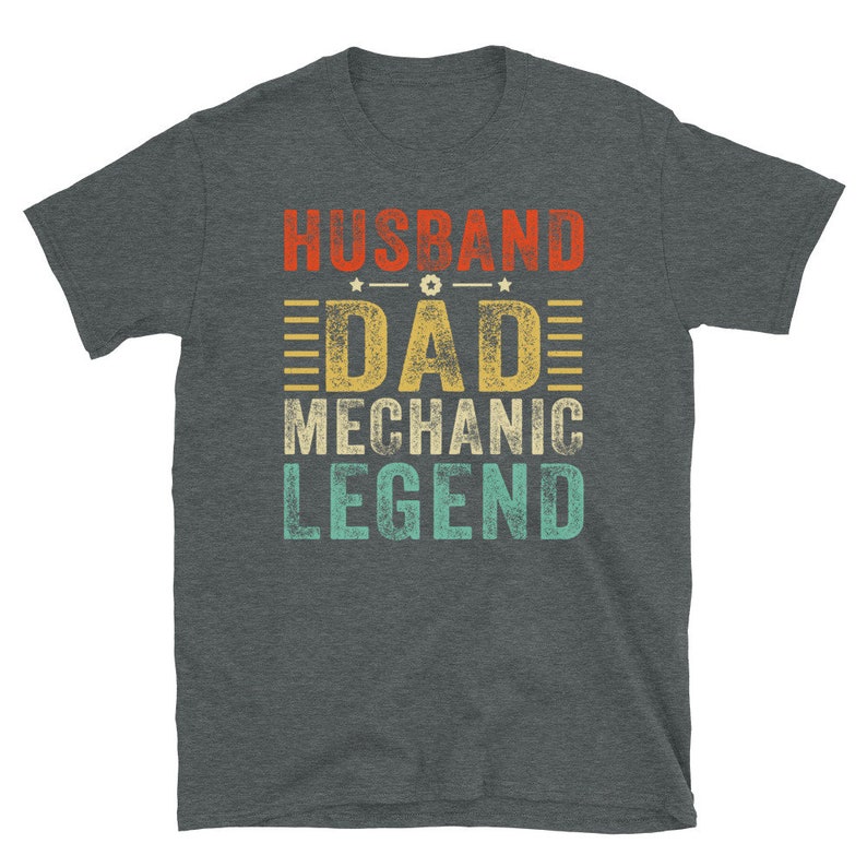 May include: A dark heather grey t-shirt with a vintage-style graphic that reads "Husband Dad Mechanic Legend".