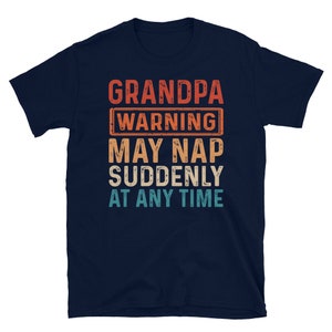 May include: A navy blue t-shirt with a vintage-style graphic that reads "Grandpa Warning May Nap Suddenly At Any Time".