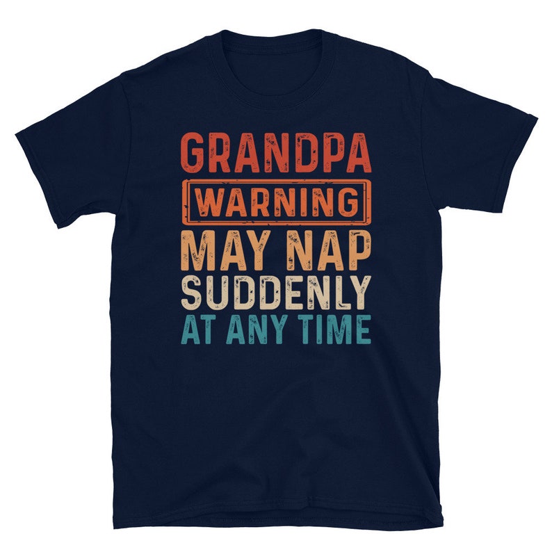 May include: A navy blue t-shirt with a vintage-style graphic that reads "Grandpa Warning May Nap Suddenly At Any Time".