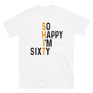 Peut inclure: T-shirt blanc avec du texte noir qui dit "SO HAPPY I'M SIXTY" avec le mot "SIXTY" en orange.