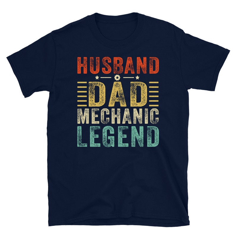 May include: Navy blue t-shirt with a vintage-style graphic that reads "Husband Dad Mechanic Legend".