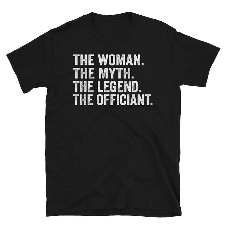 Puede incluir: Camiseta negra con texto blanco: "THE WOMAN. THE MYTH. THE LEGEND. THE OFFICIANT." La camiseta es de material suave y tiene mangas cortas. El texto est&aacute; en negrita, con fuente sans-serif.