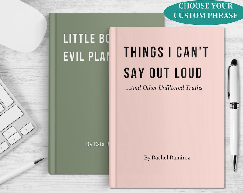 May include: Two hardcover books with text. One is sage green with the title "Little Bo Evil Plan". The other is light pink with the title "Things I Can't Say Out Loud". A pen and keyboard are in the background.