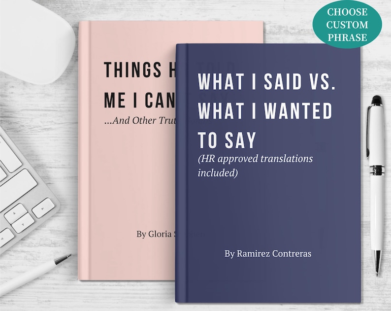 May include: Two hardcover books, one blush pink and one navy blue, are displayed. The pink book reads "THINGS H ME I CAN...And Other Truths" and the blue book reads "WHAT I SAID VS. WHAT I WANTED TO SAY (HR approved translations included)". A white pen and keyboard are also visible.