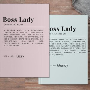 May include: Two pink and blue cards with the text "Boss Lady" and the definition of the word. The text on the pink card reads "A person who is a remarkable leader with vision, compassion, and determination. Her guidance inspires, her empathy supports, and her strength empowers others. She transforms challenges into opportunities, making a lasting positive impact." The text on the blue card reads "Person who is a remarkable leader with vision, compassion, and determination. Her guidance inspires, her empathy supports, and her strength empowers others. She transforms challenges into opportunities, making a lasting positive impact." The pink card also has the text "See also: Lizzy" and the blue card has the text "Also: Mandy".