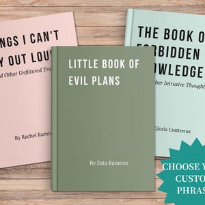 May include: Three books with titles: "Things I Can't Say Out Loud", "Little Book of Evil Plans", and "The Book of Forbidden Knowledge". The books are in pink, green, and light blue, with white text. A teal starburst graphic says "Choose Your Custom Phrase".