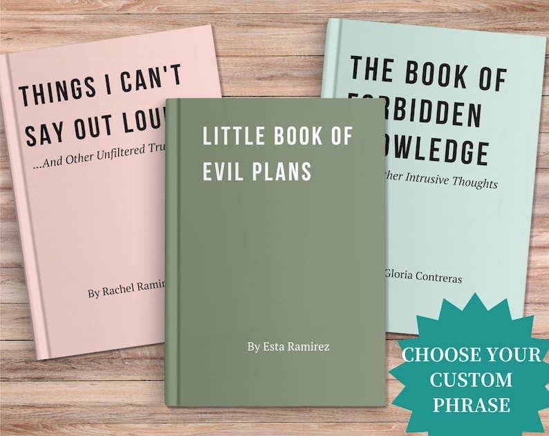 May include: Three books with titles: "Things I Can't Say Out Loud", "Little Book of Evil Plans", and "The Book of Forbidden Knowledge". The books are in pink, green, and light blue, with white text. A teal starburst graphic says "Choose Your Custom Phrase".